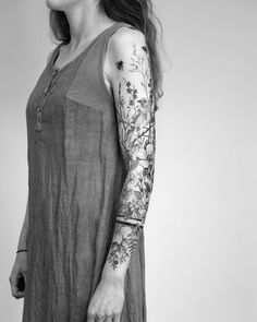 a woman with tattoos on her arm holding a suitcase