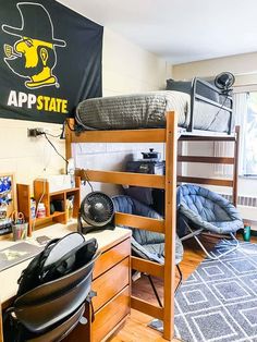 a room with bunk beds, desk and chair in the corner next to a window