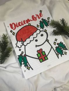 a notepad with a drawing of a snowman holding a christmas present on it