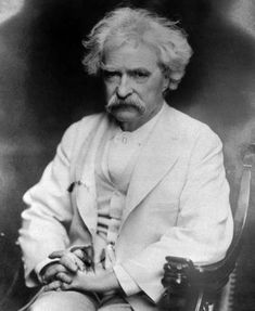 an old black and white photo of a man in a suit sitting on a chair