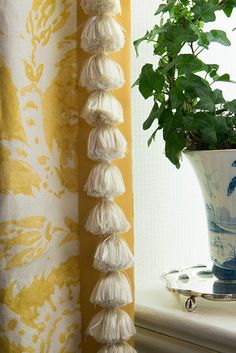 a potted plant sitting on top of a window sill next to a curtain