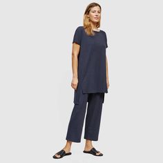 A Stretchy Rib Knit Adds Dimension To A Bateau Neck Tunic With A Dramtic Stepped Hem And Side Slits. Bateau Neck; Short Sleeve; Tunic Length; Hi-Low Hem. Designed With An Easy, Straight Fit. 31” Length (Front); 34” Length (Back); 3 ½” Side Slits; 19” Across. 88% Tencel Lyocell, 12%Elastane. Machine Wash Cold. Fiber Made From Responsibly Harvested Trees. Knit, Cut, & Sewn In The Us. Brand New & Unworn, Perfect Condition New With Tags!!!! No Flaws, Defects, Or Other Imperfections. Model/Fit Info M Eileen Fisher Leggings, Womens Pants Design, Loose Fit Sweater, Black Tunic Tops, Spaghetti Strap Mini Dress, Bateau Neck, Tunic Tank Tops, Long Shirt Dress, Sleeveless Tunic