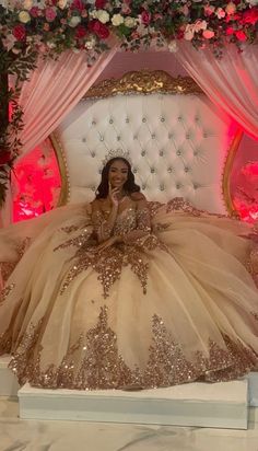 a woman sitting on top of a white bed in a wedding dress with gold sequins