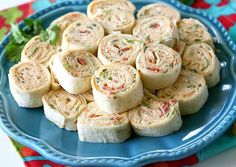 a blue plate topped with rolls on top of a table