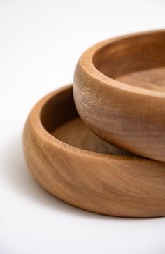 two wooden bowls sitting on top of each other