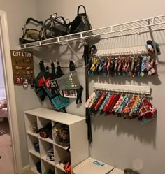 an organized closet with lots of items on the shelves and bags hanging from it's hooks