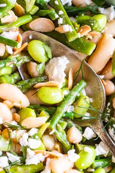 asparagus, beans and feta cheese in a bowl with two spoons