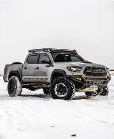 a gray truck is parked in the snow