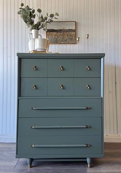 a blue dresser with brass handles and knobs