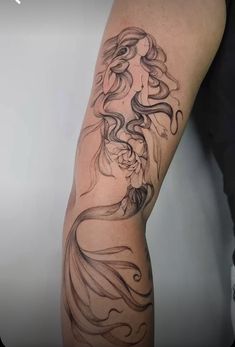 a woman's arm is covered in black ink and has an intricate design on it