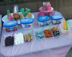 a table topped with lots of desserts and icecream cups on top of it