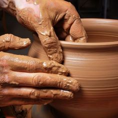 someone is making a vase out of clay on a potter's wheel with their hands