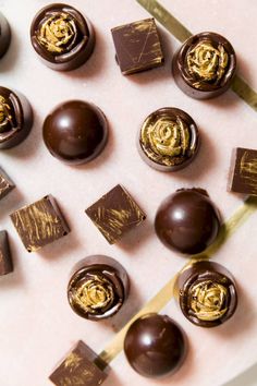 chocolates with gold swirl designs on them sitting on a table