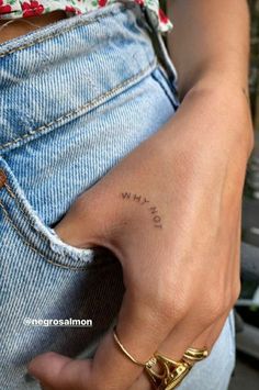 a person with a small tattoo on their left hand and the word love is written in cursive writing