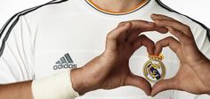 a man making a heart shape with his hands while wearing a real madrid soccer shirt