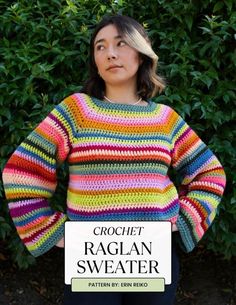 a woman standing in front of some bushes with her hands on her hips, wearing a multicolored crochet sweater