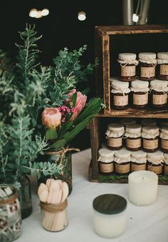 a table topped with lots of candles and vases filled with flowers next to each other