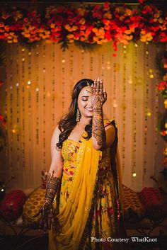 a woman in yellow dress holding her hands up