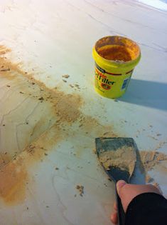 a person is using a spatula to remove dirt from the floor