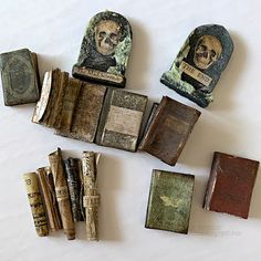 several old books are laying on the floor next to each other with skulls and faces painted on them