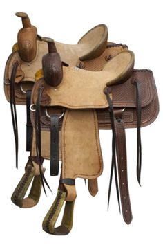 a saddle with two boots on it and some other items hanging off the side of it