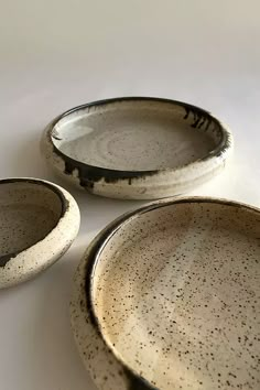 three white and black dishes sitting on top of a table