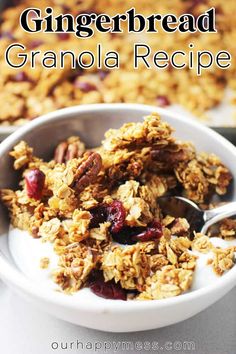 a white bowl filled with granola topped with nuts and cranberries next to a spoon