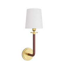 a wall light with a white shade on the top and a brown cord attached to it