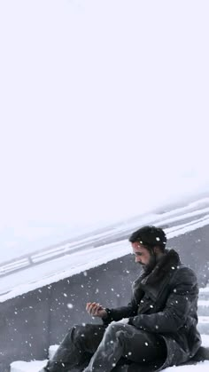 a man sitting on top of snow covered ground