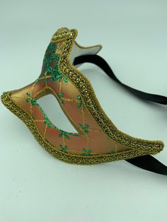 "This is a very nice original handmade and hand painted Venezia masquerade face mask made in Italy. The design on the shiny gold and orange face mask features turquoise blue and multi-color glitter with a border of gold lace and gold rope around the edges. It comes with a black ribbon tie and is stamped on the back \"Original Hand Painted Made in Italy Venezia\". The mask measures approximately 6 5/8\" long and 3 3/4\" wide and is in very good preowned condition with light wear on the back of th Adjustable Masquerade Mask For Mardi Gras, Venetian Mask For Mardi Gras Costume, Venetian Masks For Mardi Gras Costume Party, Venetian Masks For Mardi Gras, Venetian Masks For Mardi Gras Carnival, Handmade Masks And Prosthetics For Mardi Gras Costume Party, Festival Masks And Prosthetics As Gifts, Adjustable Masks For Carnival Costume Party, Handmade Masquerade Mask For Mardi Gras Costume Party