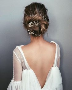 the back of a woman's head, wearing a white dress and hair comb