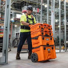 a man standing next to a stack of orange boxes