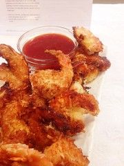 some fried food is sitting on a plate with ketchup and dipping sauces