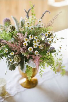 a vase filled with lots of flowers on top of a table