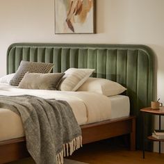 a bed with green headboard and pillows in a bedroom