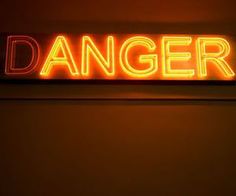 a neon sign that says danger on the wall