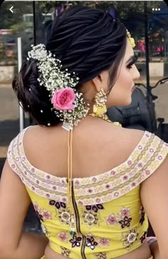 a woman wearing a yellow dress with flowers in her hair and an elaborate head piece