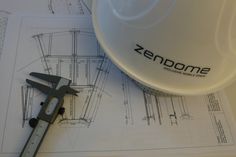 a pair of pliers sitting on top of blueprints next to a measuring cup