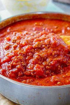 a metal pan filled with sauce on top of a table