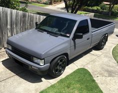 a silver truck parked in front of a wooden fence