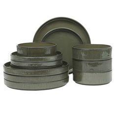 a stack of green dishes sitting next to each other on top of a white surface