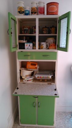 an old fashioned kitchen cabinet with green doors