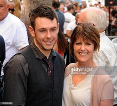 a man and woman standing next to each other in front of an outdoor area full of people