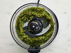 a food processor filled with pesto on top of a counter