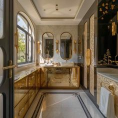 an elegant bathroom with gold accents and marble flooring, along with large windows that look out onto the outdoors