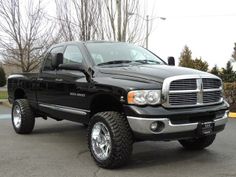 a black dodge ram truck parked in a parking lot