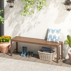 a wooden bench sitting next to a potted plant