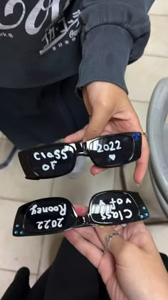 two people holding up some cell phones with writing on them