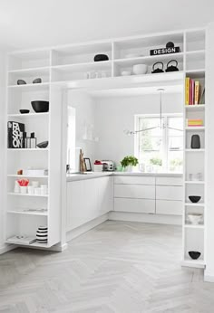 an open kitchen with white cabinets and shelves