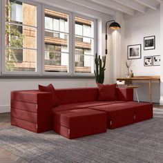 a living room with a red couch and large windows